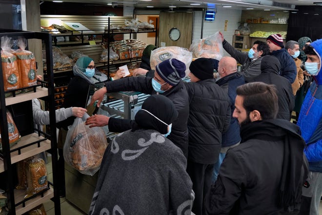 People queue for bread inside a bakery in the southern Beirut suburb of Dahiyeh, Lebanon, Tuesday, March 15, 2022. Soaring energy and food prices triggered by Russia's invasion of Ukraine are pushing some Middle Eastern countries to the brink. Economically devastated by years of grinding civil wars, endemic corruption and the pandemic, residents are now gripped by a new worry. (AP Photo/Bilal Hussein)