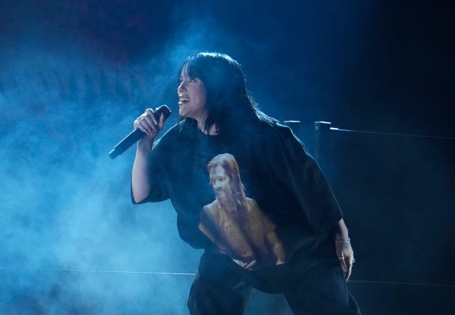 Billie Eilish performs “Happier Than Ever” during the 64th Annual Grammy Awards at the MGM Grand Garden Arena in Las Vegas. EIlish is wearing a shirt featuring an image of Foo Fighters drummer Taylor Hawkins.