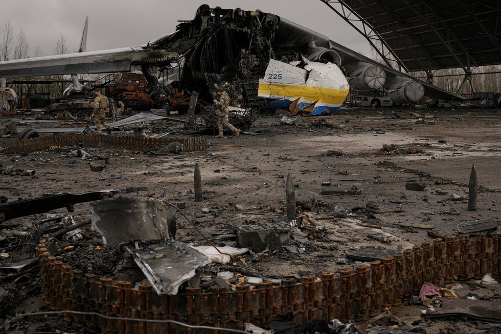 Des militaires ukrainiens passent devant l'avion détruit Antonov An-225 Mriya.