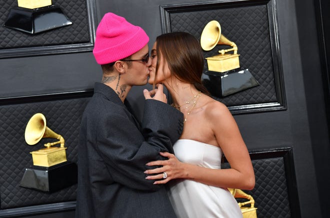 Justin Bieber and Hailey Bieber share a kiss at the 64th Grammy Awards in April 2022.