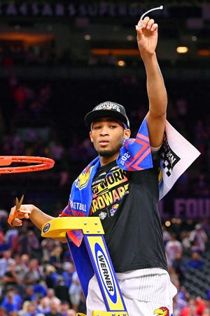 Kansas guard Dajuan Harris Jr. (3) reacts after cutting down the net following a win over North Carolina in the 2022 NCAA men's basketball tournament Final Four championship game Monday night at Caesars Superdome in New Orleans.