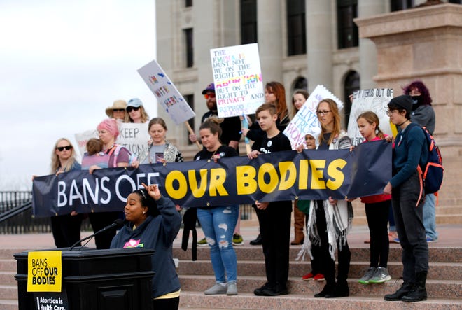 People hold signs during the Bans Off Oklahoma Rally on the steps on Oklahoma state Capitol in Oklahoma City, Tuesday, April, 5, 2022.