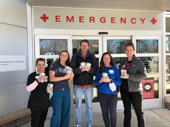 Exeter Hospital Emergency Department providers accept the donation of teddy bears from Geoffrey Pendexter, owner of Whirlygigs (middle).