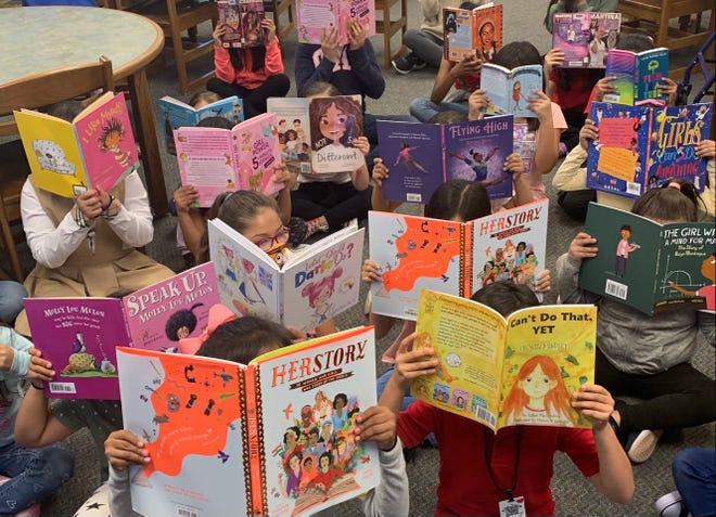 Enthusiastic young readers show off their new books at Sea View Elementary on March 29, 2022.