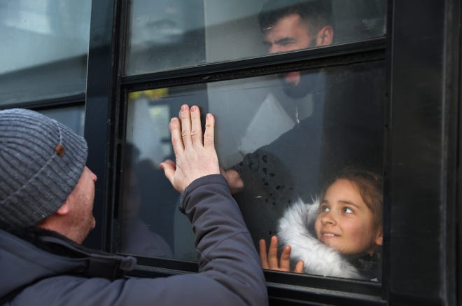 A volunteer (L) bids farewell to Ukrainians who are seeking asylum as they gather on a bus on their way to the El Chaparral port of entry, before entering the United States amid the Russian invasion of Ukraine, on April 6, 2022 in Tijuana, Mexico. Authorities opened the El Chaparral port of entry today solely for the processing of Ukrainian asylum-seekers. U.S. authorities are allowing Ukrainian refugees to enter the U.S. at the Southern border in Tijuana with permission to remain in the country on humanitarian parole for one year.  