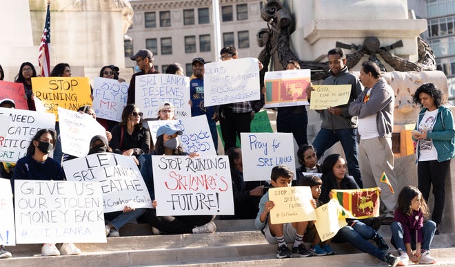Sri Lankan Americans hold signs and flags on April 3, 2022 in front of the Monument Circle in Indianapolis to demonstrate in solidarity with Sri Lankans suffering an unprecedented economic crisis.