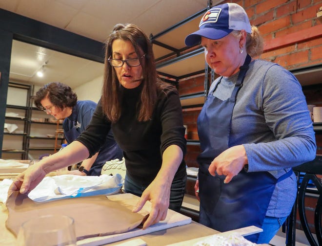 Sylvana Whittaker (left), owner of Uptown Art & Clay, helps Westerville resident Sydney Smith roll out a slab of clay that she will use to make a wall pocket during a small-group class at the Westerville studio April 2.