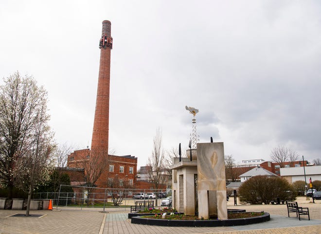 The Johnson Creamery Business Center smokestack is seen April 7 from the B-Line Trail. An area around the deteriorating structure has been blocked off for safety reasons until it can be shortened from 140 to 60 feet.