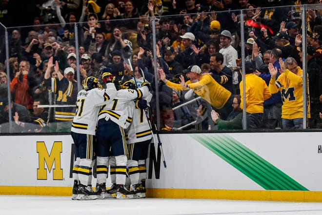 Michigan players celebrate a goal scored by striker Jimmy Lambert against Denver in the second period of the Frozen Four semifinal at TD Garden in Boston on Thursday, April 7, 2022.