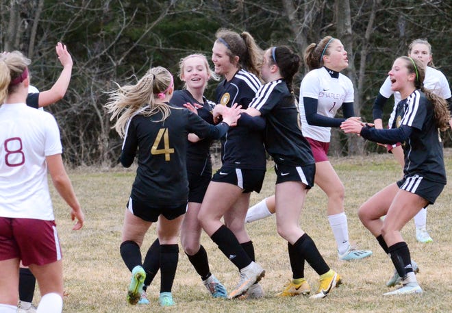 Harbor Springs teammates rush in to celebrate with teammate Hailey Fisher (middle) after she scored on a penalty kick in the second half to put the Rams up two goals on rival Charlevoix.