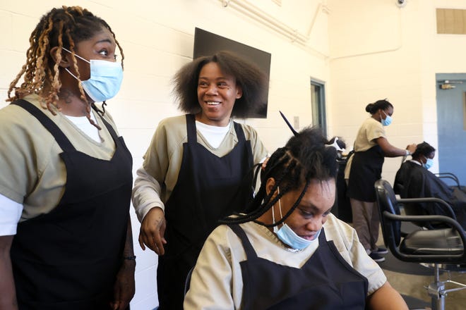 Zana Smith, left, and Tionna Jones share a laugh as they work on braiding the hair of Latrice Brown during the inaugural natural hair program class at the Shelby County Division of Corrections, where women inmates learn style techniques while working towards accreditation on Thursday, April 7, 2022. The class, which began in February of this year, is one of the Shelby County Office of Reentry programs for inmates and former inmates to help them reenter into society. 