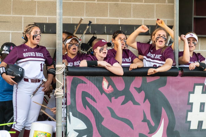 Players in the Round Rock dugout cheer on the Dragons during Round Rock's 7-2 win in a district softball game April 8.