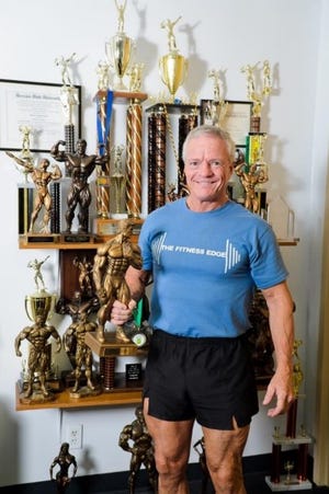 Bill Neylon with many bodybuilding awards.