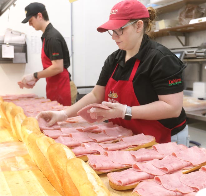 Dominic DiMascio and Chloe Derus of DeVitis Italian Market in Akron assemble 15-inch Angelo's Italian Hoagies on Sunday. DeVitis sandwiches are now sold at many BellStores.