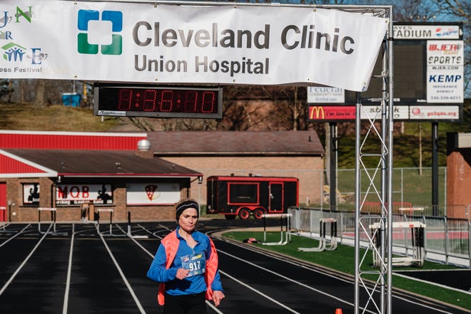 Teresa Ferguson, of Coventry Township, crosses the finish line to take first place in the women's division of the half marathon, with a time of 1:36:09, at the 15th annual Cleveland Clinic Union Hospital Run for Home on Sunday.