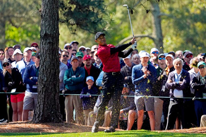 Tiger Woods hits out of the rough and onto the green at the first hole on Sunday's final round of the Masters.