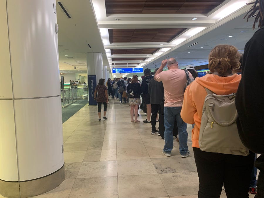 Passengers wait in line to reach the Spirit Airlines customer service desk at Orlando International Airport late Saturday after the budget airline canceled late-night flights to several destinations.