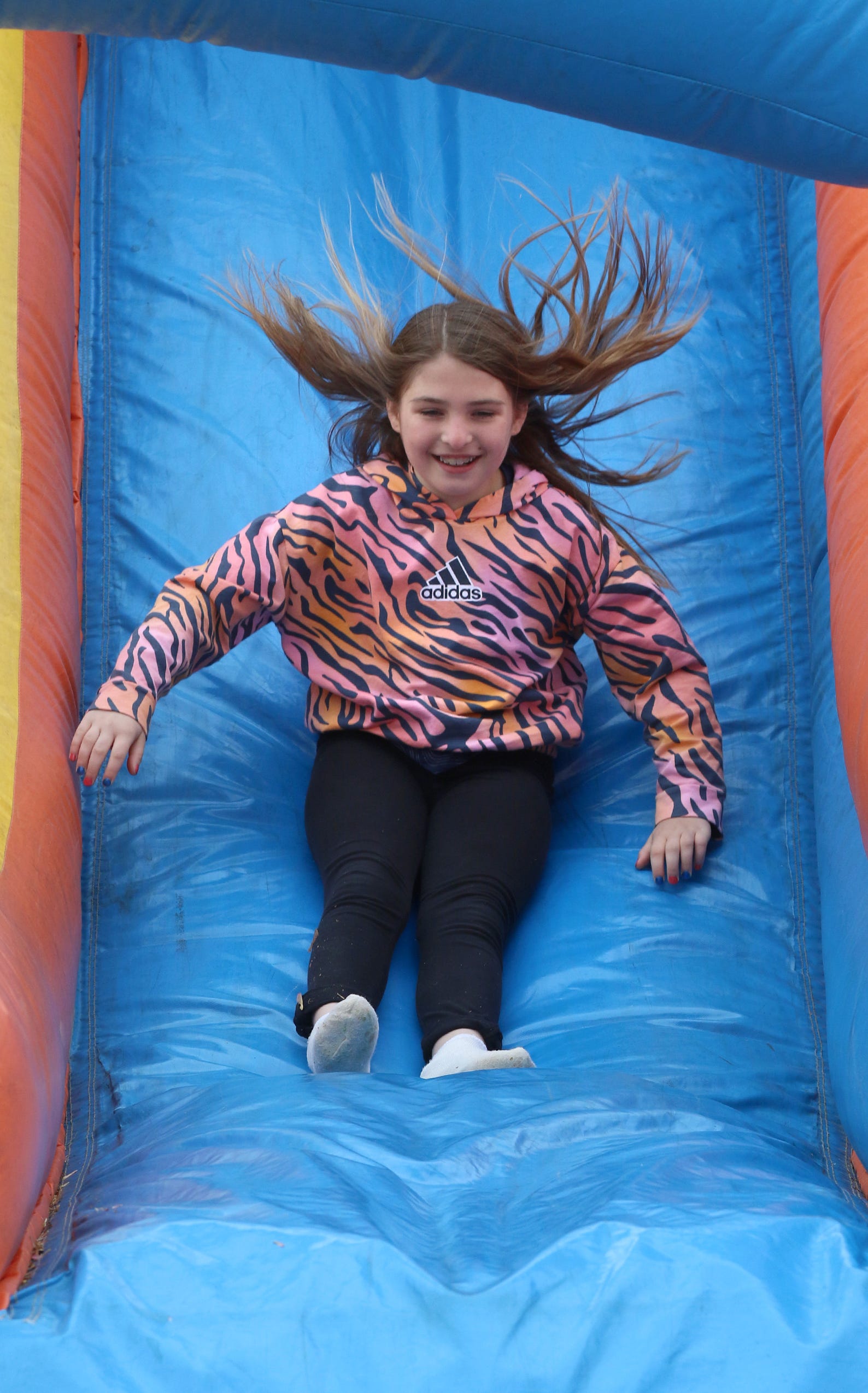 Nine-year-old Olivia Grzonka has fun on the inflatable slide during the Honey Hunters Community Day held Saturday, April 9, 2022, at CaroMont Health Park.