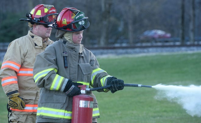 Hunter Smith, 13, extinguishes an intentionally set training fire with instruction from Todd Smith, who is a lieutenant with the Newark Fire Department and volunteers for Newton Township, during a meeting of the Newton Township Fire Department's junior program. The program, which recently restarted, hopes to mold the next generation of firefighters as they prepare for training programs like those at C-TEC or COTC.