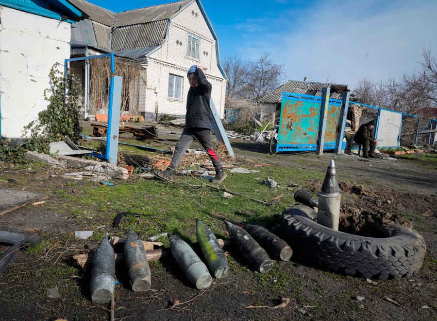 A boy walks by unexploded Russian shells in the village of Andriyivka close to Kyiv, Ukraine, Monday, Apr. 11, 2022. Andriyivka was occupied by the Russian troops at the beginning of the Russia-Ukraine war and freed recently by the Ukrainian army.