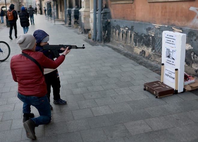LVIV, UKRAINE - APRIL 11: A child uses an air rifle to shoot at a target with the face of Russian President Vladimir Putin on it on April 11, 2022 in Lviv, Ukraine. Lviv has served as a stopover and shelter for the millions of Ukrainians fleeing the Russian invasion, either to the safety of nearby countries or the relative security of western Ukraine. (Photo by Joe Raedle/Getty Images) ORG XMIT: 775797356 ORIG FILE ID: 1390891670