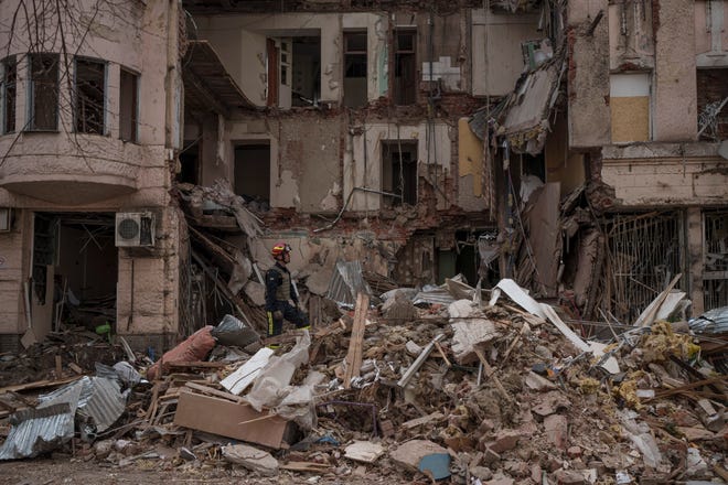 Firefighters clear debris and search for bodies under the rubble of a building in Kharkiv, Ukraine, on April 11, 2022.