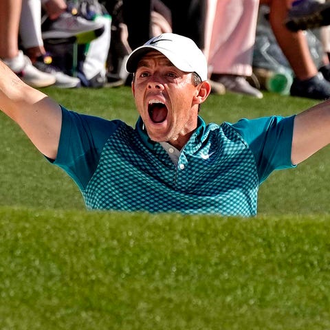 Rory McIlroy celebrates after holing out from a bu