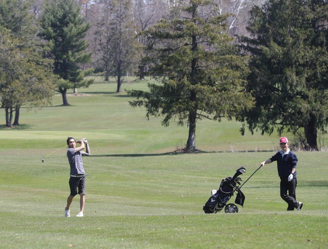 Kai Rassavong, left and Paul Yoon enjoy a round of golf Tuesday at Loyal Oak Golf Course in Norton.
