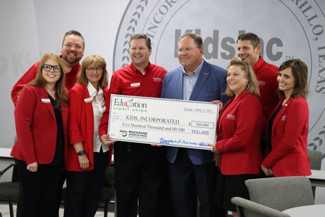 Staff from the Education Credit Union stand with Jimmy Lackey, center, president and CEO of Kid's Inc, as they announce a donation of $500,000 for the Rockrose Sports Park with the Home Field Advantage Campaign.