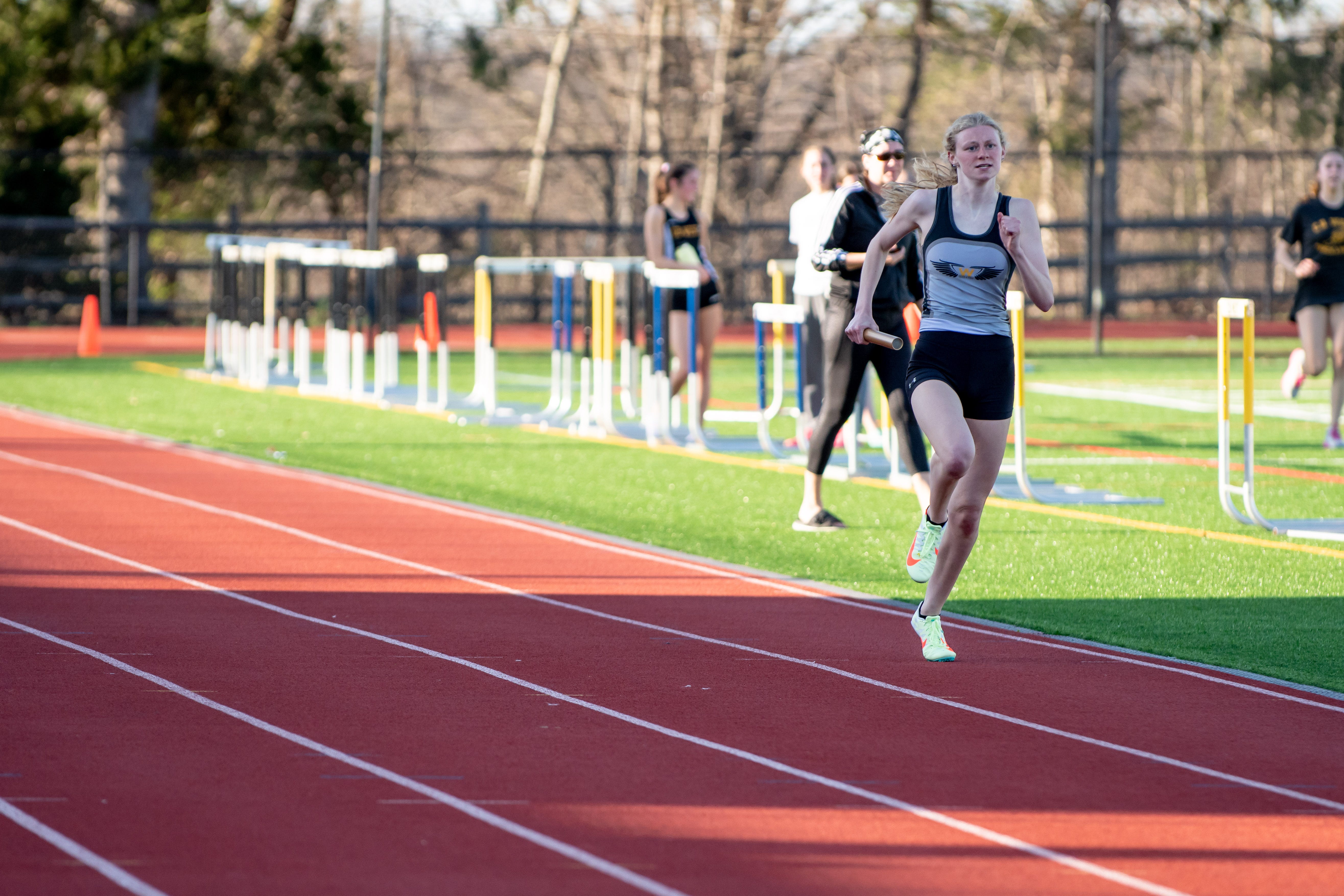 Central Bucks West's Kate Edensen runs the 4x400 relay during a meet against Central Bucks South, on Tuesday, April 12, 2022, at Central Bucks West.