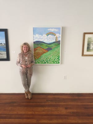 Dublin artist Gaynelle Sloman posing beside her painting "Chloe's Message" at the Denison Art Space in Newark in 2019. The painting, now titled "Rainbow Dreams," was turned into a flag and is currently being flown at Rockefeller Center in New York City.