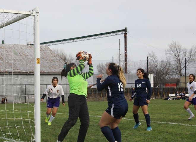 Monmouth-Roseville goalkeeper Rosa Perez finishes off her save of a Mendota shot that nearly slipped in under the crossbar during action Monday afternoon at Pattee Fields. The save was a big one, as it helped preserve a 0-0 tie for the Titans against their TRAC visitors. Also pictured for Mon-Rose are Lindsey Andrade (19) and Paula Castaneda (18).