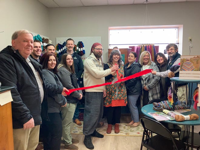 Cutting the ribbon at the new Maker's Way Studio are Misha Thibault, left, and Mellacent Thibault, right, surrounded by some very supportive chamber members.