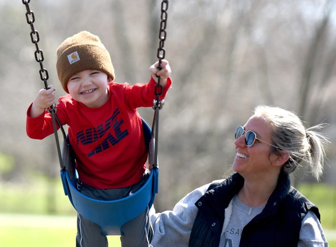 Myles McCallion, 3, gets an assist from mother, Ally McCallion of North Canton, on a visit to Price Park in North Canton on a warm, sunny afternoon last week.