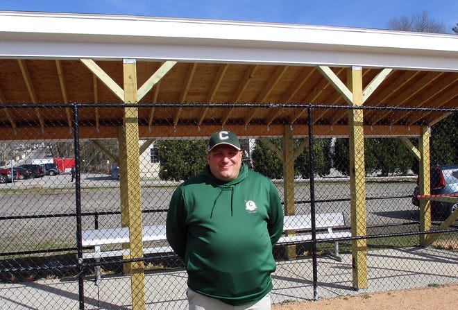 Clinton Area Little League President Matt Kobus stands in front of one of the newly renovated dugouts at Savage Field.