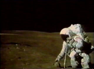 TV camera still image showing Charlie Duke about to capture sample 61016, known as 