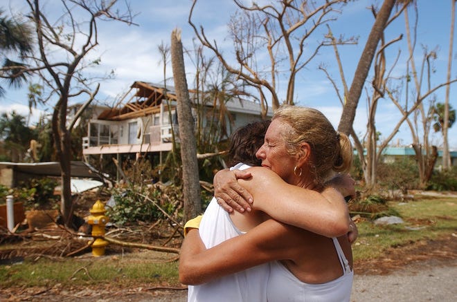 Captiva Island resident Sherrill Sims gets a hug from resident and friend Mary Bates days after Hurricane Charley ripped through the area in August 2004. It was the first time they'd seen each other since the storm, which Sims rode out on the island.