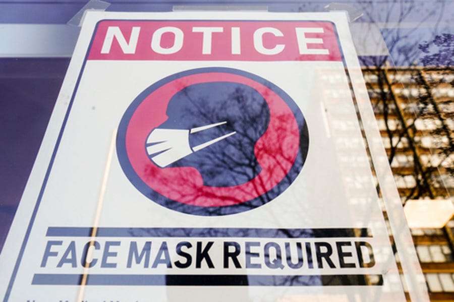 A sign requiring masks as a precaution against the spread of the coronavirus on a store front in Philadelphia, is seen Feb. 16, 2022.