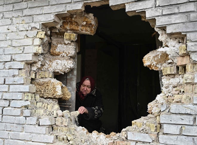 Local resident Nadiya, 65, shows a hole in a house after shelling in the village of Zalissya, northeast of Kyiv, on April 12, 2022. - While Russia appears to have abandoned for now its aim of pushing deep into the heart of Ukraine, its new declared goal of taking control of much of the east of the country still risks a protracted and bloody conflict. (Photo by Genya SAVILOV / AFP) (Photo by GENYA SAVILOV/AFP via Getty Images) ORG XMIT: 0 ORIG FILE ID: AFP_32888PN.jpg