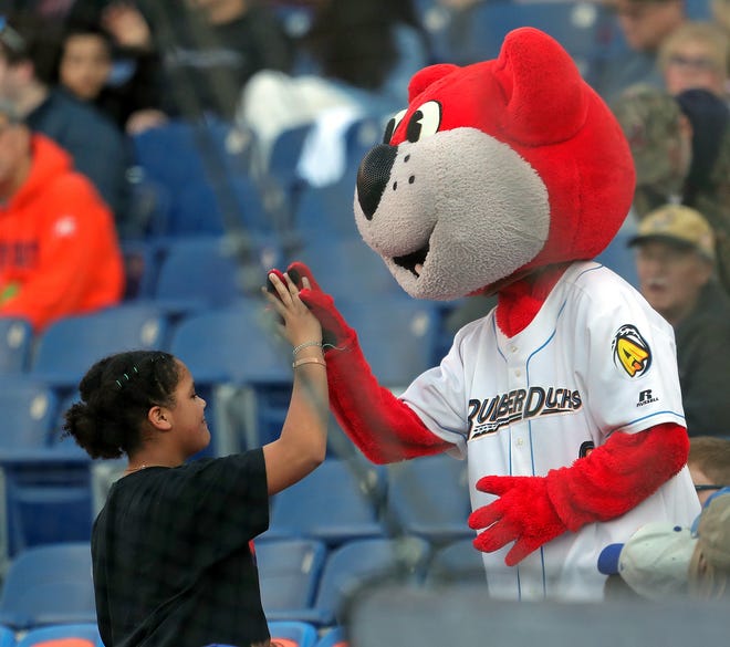 A young Akron RubberDucks fan high fives Orbit during the first inning of a Minor League Baseball game at Canal Park.