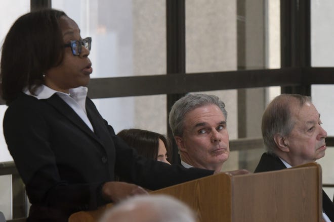 BOSTON - Worcester District Attorney Joseph D. Early Jr., center, looks on as State Ethics Commission lawyer Candies Pruitt makes her opening statement in the ethics case against him Wednesday, April 13, 2022.