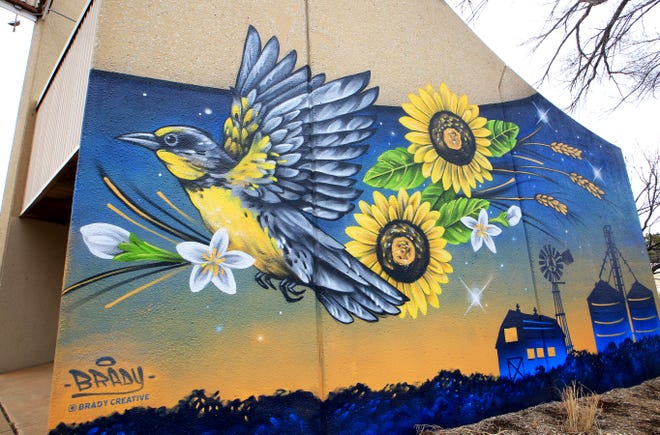 One-half of a mural titled 'To the stars' that was painted by local artist Brady Scott features state symbols of the meadowlark, sunflowers, wheat and a farm scene and was commissioned and painted on the wall of the Visit Hutch visitor center at the Kansas State Fair. 