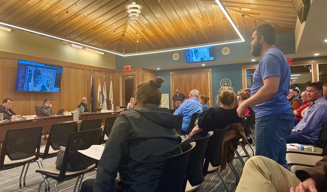 Mike Castiglione (standing right), owner of Stiggs Brewery and Kitchen, answers questions from the Boyne City commissioners on Tuesday, April 12.  Castiglione has requested to permanently rent several public parking spaces the city has allowed him to temporarily use for outdoor dining during the pandemic.