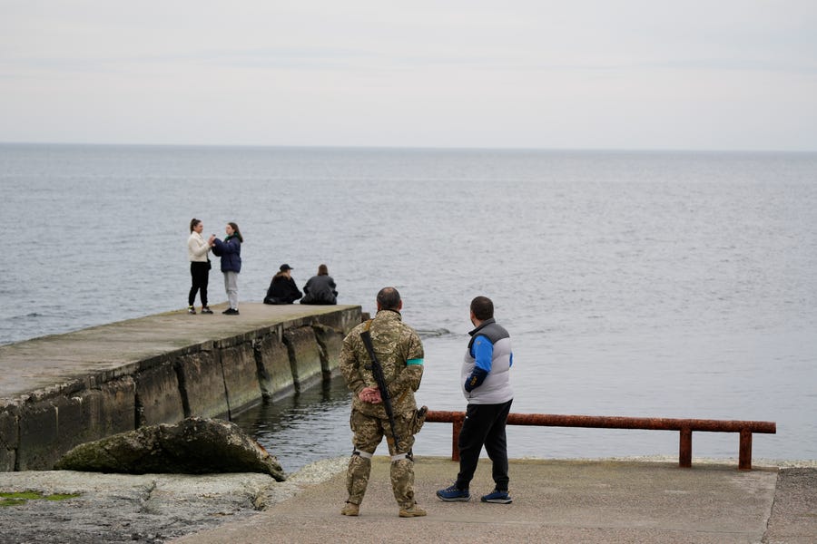 People sit and walk on a boardwalk along the Black Sea in Odesa, Ukraine on April 14, 2022. On Wednesday, the Russian ship Moskva, currently in the Black Sea, was badly damaged after an explosion and fire aboard the vessel. The Pentagon, Russia and Ukraine all provided divergent explanations for the fate of the Moskva.