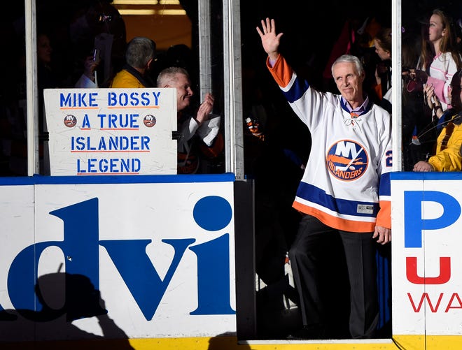 FILE - Hockey Hall of Famer and former New York Islander Mike Bossy waves to fans as he is introduced before the NHL hockey game between the Islanders and the Boston Bruins at Nassau Coliseum on Thursday, Jan. 29, 2015, in Uniondale, N.Y. Bossy dropped a ceremonial first puck. Bossy, one of hockey's most prolific goal-scorers and a star for the New York Islanders during their 1980s dynasty, died Friday, April 15, 2022, after a battle with lung cancer. He was 65. (AP Photo/Kathy Kmonicek, File)