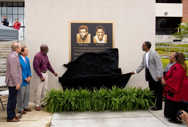 Apr 16, 2022; Tuscaloosa, Alabama, USA;  The University of Alabama honored its first two Black scholarship athletes, Wilbur Jackson and John Mitchell before the A-Day game at Bryant-Denny Stadium. Jackson, left, and Mitchell, right pull down a drape to reveal a plaque honoring them outside the stadium. Mandatory Credit: Gary Cosby Jr.-USA TODAY Sports