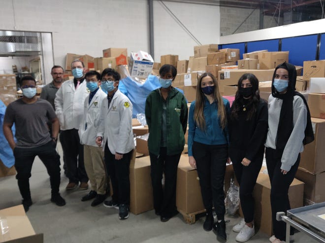 Student volunteers from Wayne State University pose for a photo inside the warehouse of World Medical Relief in Southfield on March 26, 2022. The group helped pack and prepare the boxes of medical supplies behind them for a shipment to Ukraine.
