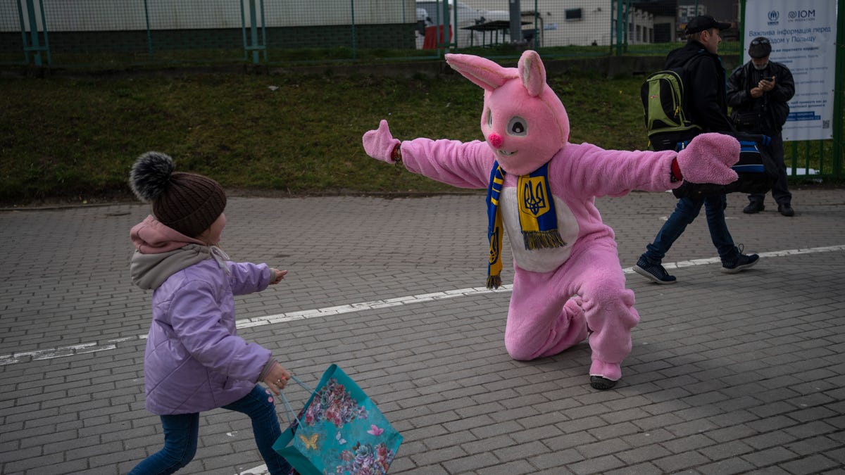 Performer Ben Dusing, from Fort Mitchell, Kentucky, wears an Easter rabbit costume as he prepares to embrace Lilia at the Medyka border crossing in Poland on April 17, 2022.