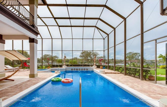 Just beyond the lanai and outdoor kitchen, this 8-foot-deep salt-water pool is screened in and surrounded by pavers.