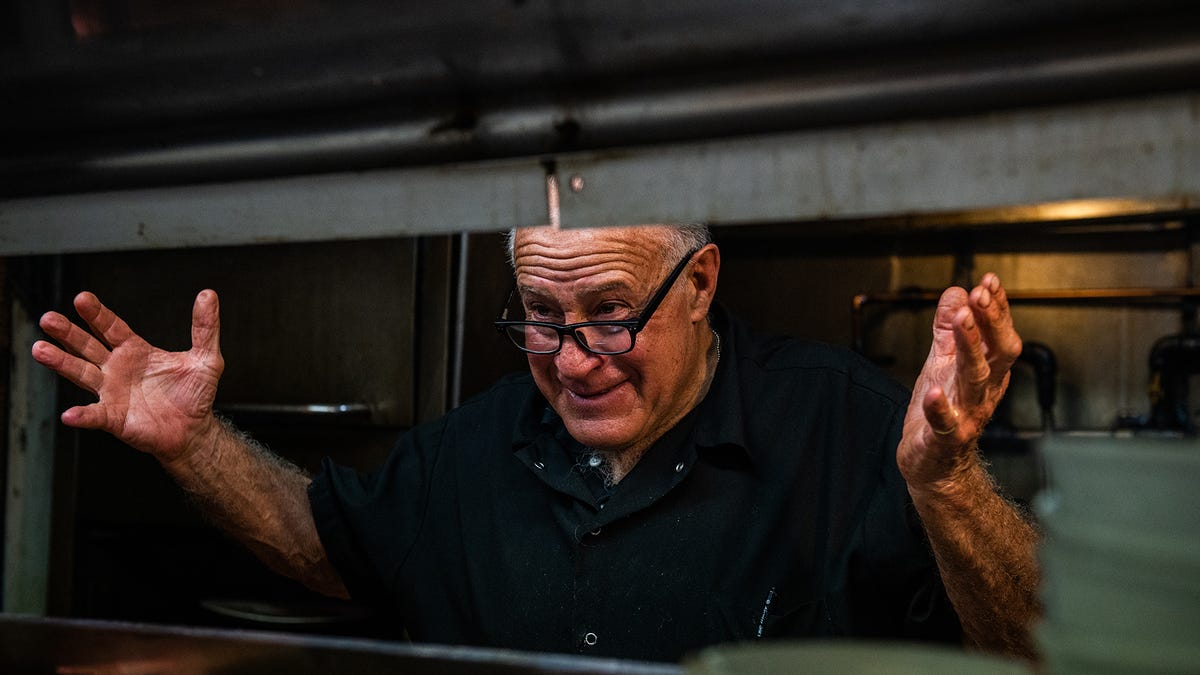 Neil Schlesinger, owner of Schlesinger's Steakhouse, throws his hands up and smiles after plating the last meal at Schlesinger's Steakhouse in New Windsor, NY on Friday, April 15, 2022.